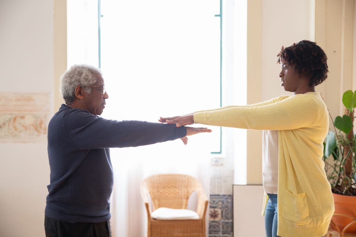 Caregiver assisting a patient with a balance and mobility exercise
